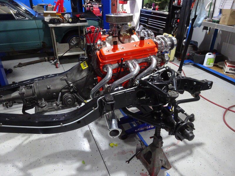 Orange V8 with chrome headers on chassis