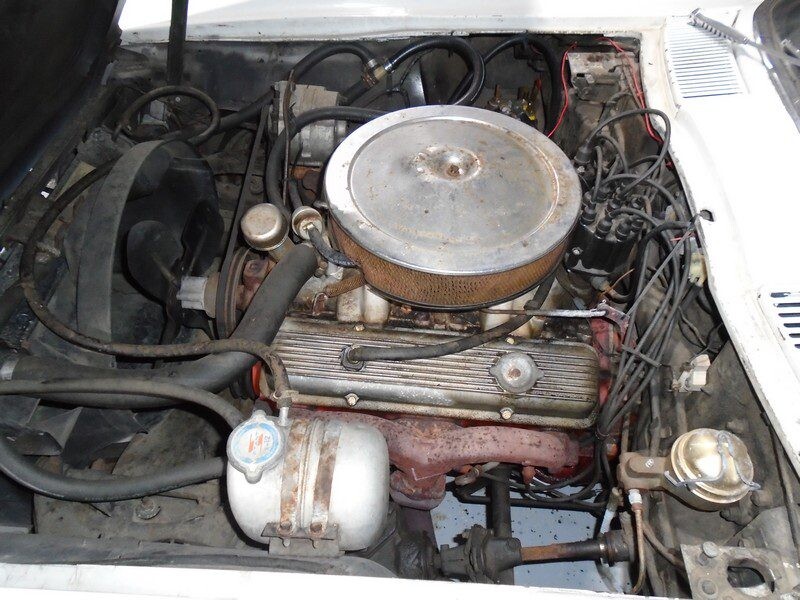 Classic car engine bay, dirty but complete.