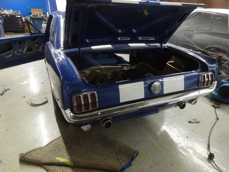 Blue Ford Mustang rear, trunk open.