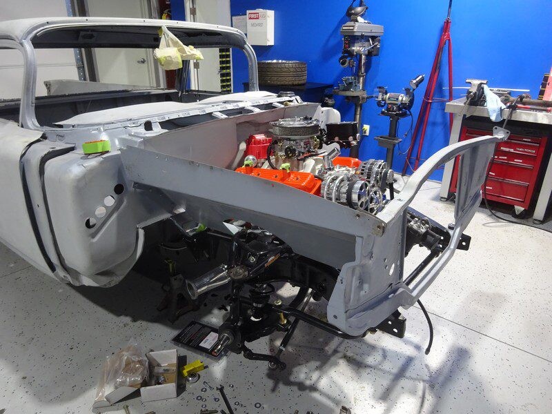 Orange small-block engine mounted in bare chassis