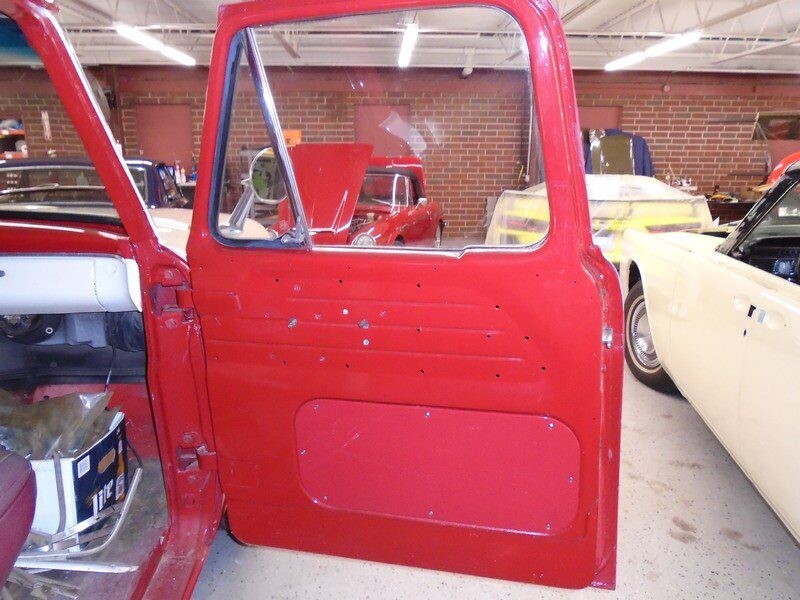 Red classic truck door panel detail.