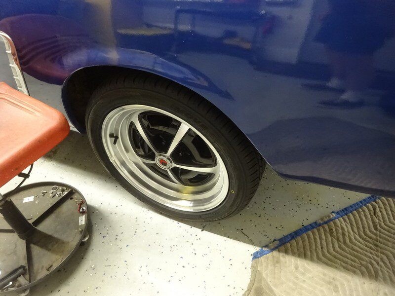 Blue classic car's rear wheel and tire.