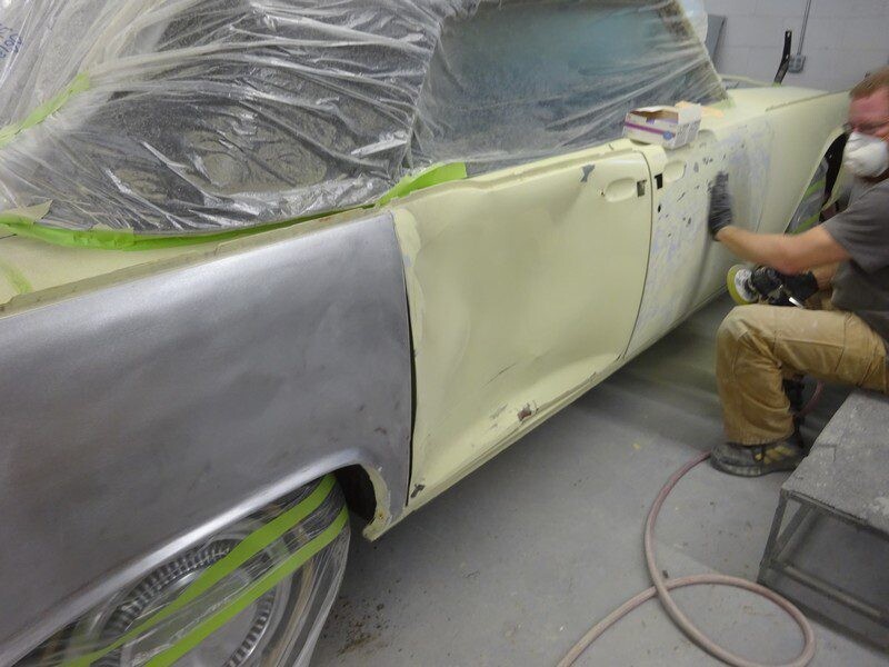Mechanic sanding classic car bodywork.