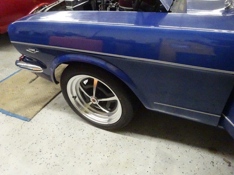 Blue classic car, front wheel view.