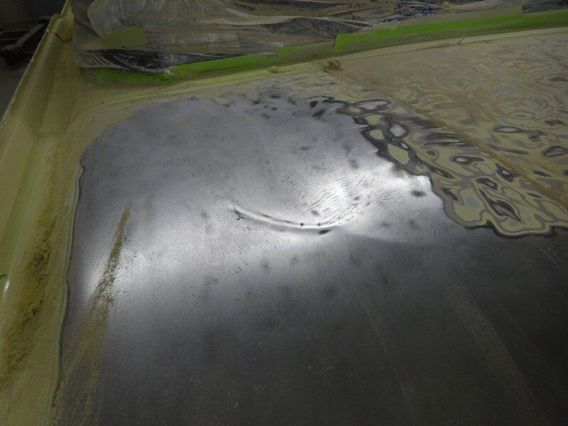 Sanded car hood metal with small dent