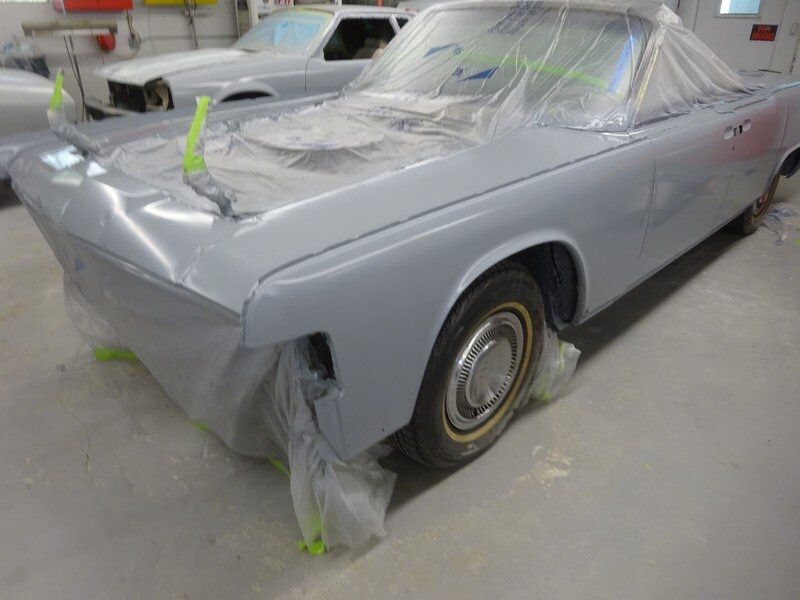 Gray classic car in auto body shop.