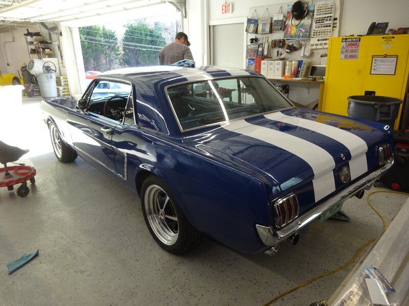Blue Ford Mustang with racing stripes.