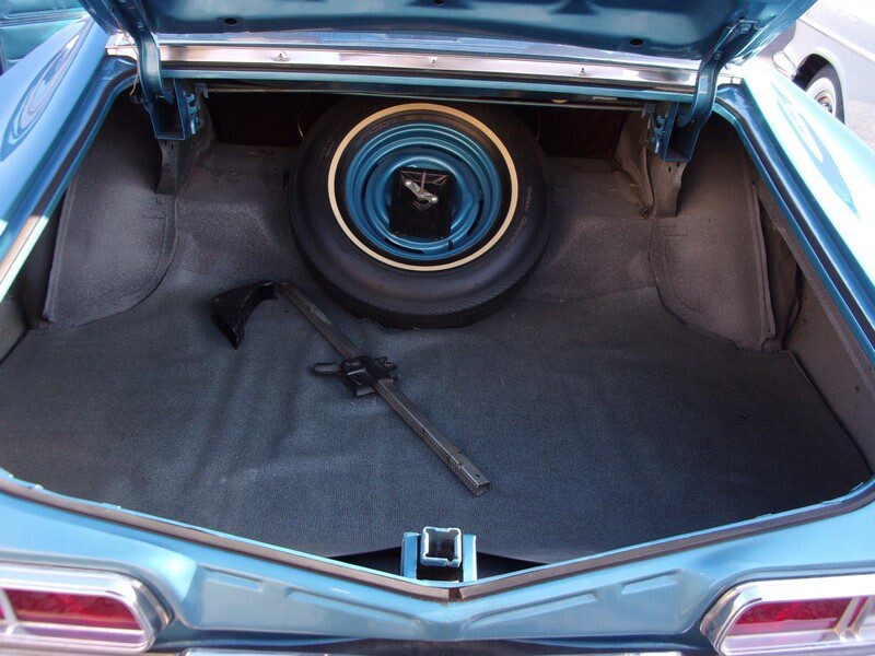 Classic car trunk with spare tire.