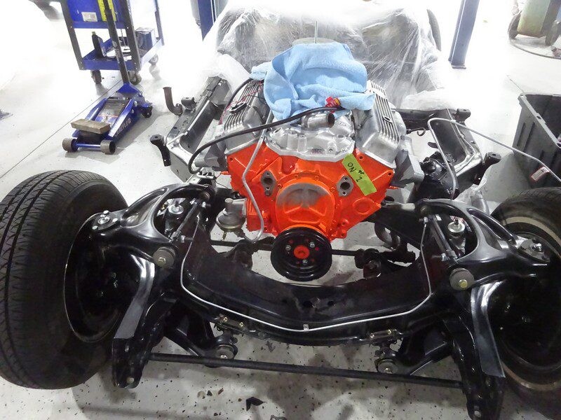 Orange V8 block mounted on restored front subframe