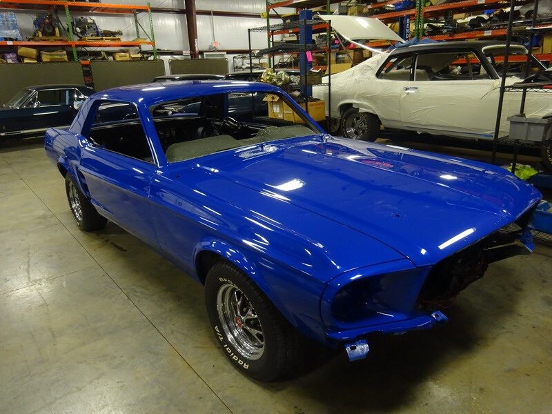 Shiny blue Mustang body in workshop
