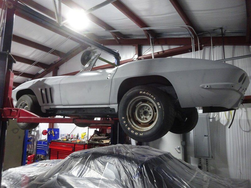 1965 Chevrolet Corvette Convertible being lifter by a crane.