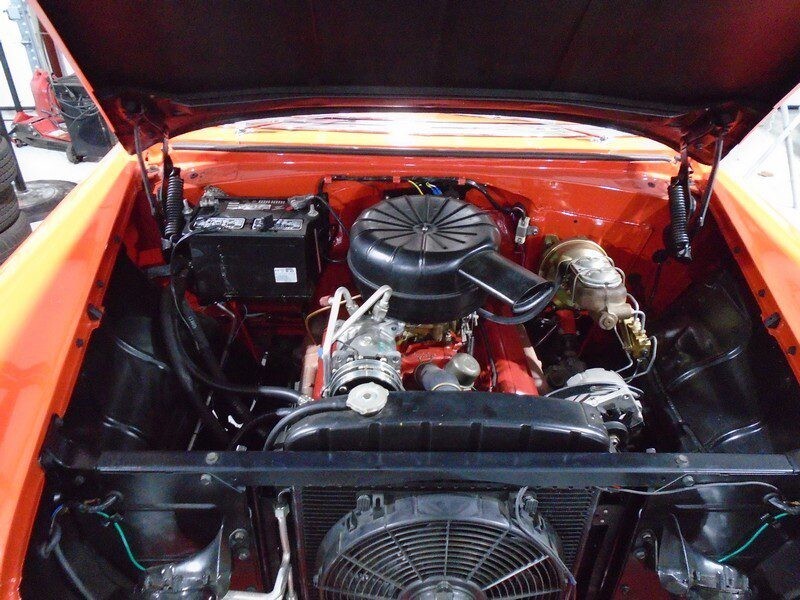 Bright orange car engine with round air cleaner