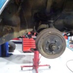 Car's rear axle and brake drum repair.