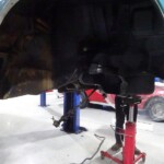 Classic car undercarriage repair in progress.