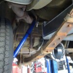 Car's undercarriage with blue shock absorber.