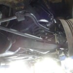 Car's undercarriage, rear suspension, and wheel.