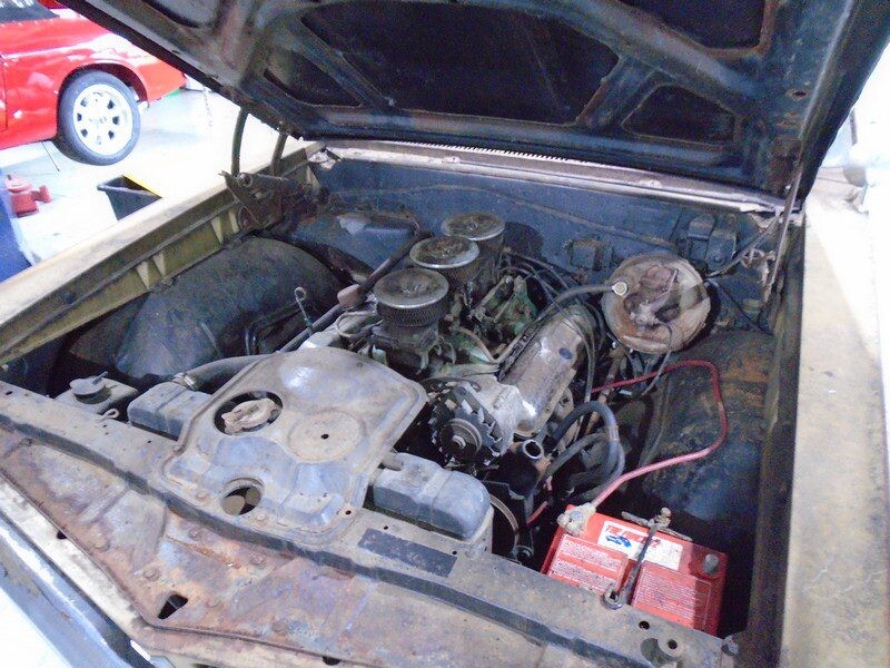 Old inline-6 engine with triple carburetors and rust