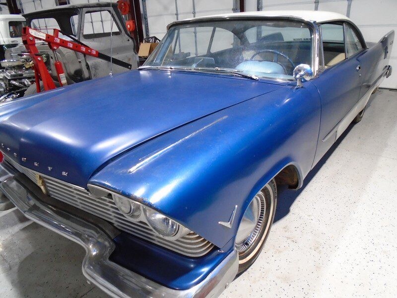 1957 Plymouth Savoy in blue standing inside a workshop.